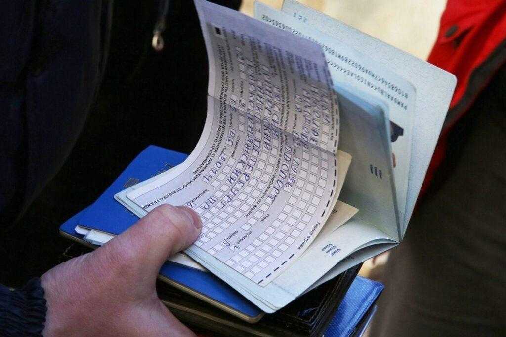 Фото заполненный бланк миграционного учета в руках